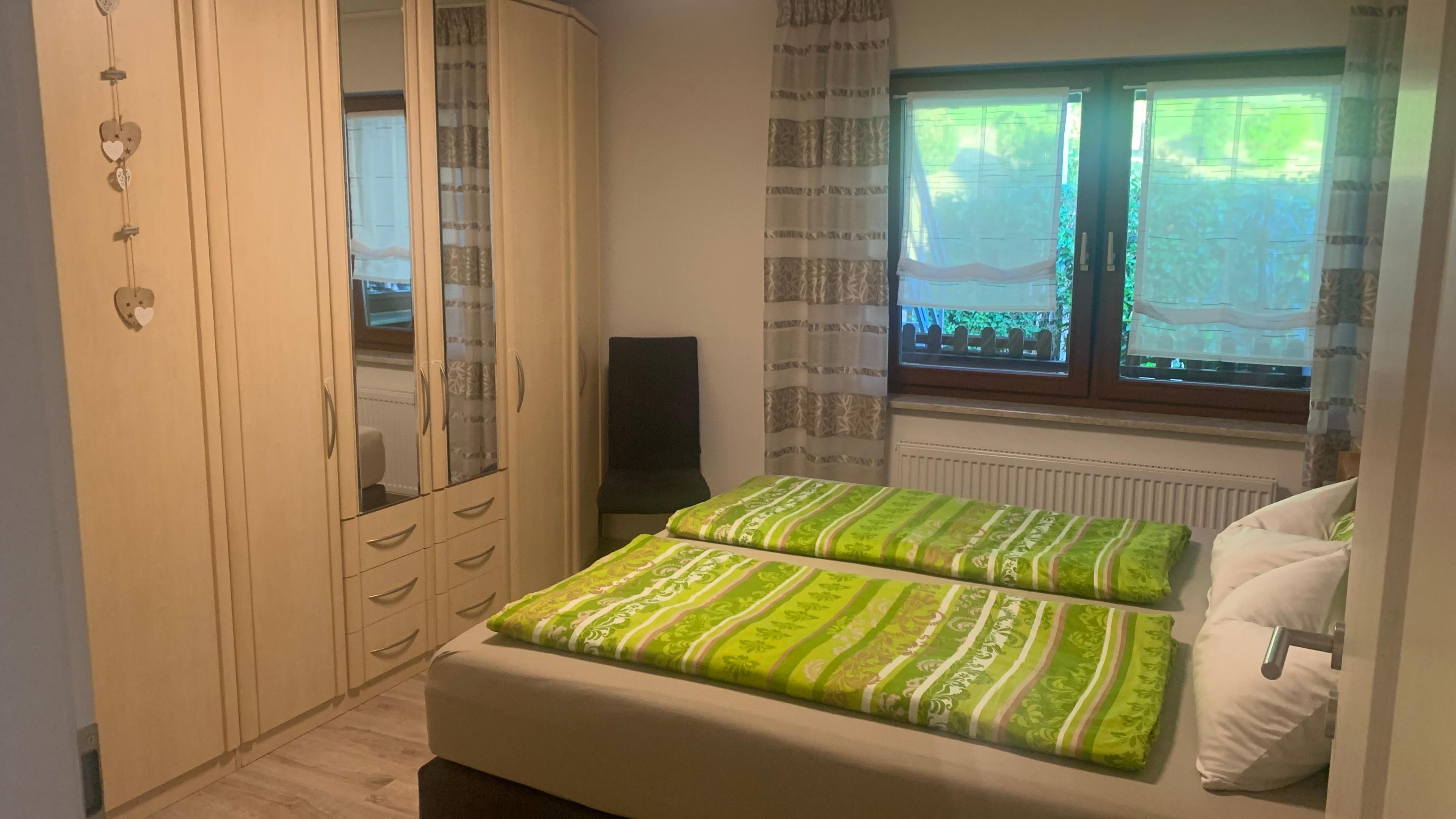 Schlafzimmer mit Doppelbett, Kleiderschrank und Schreibtisch