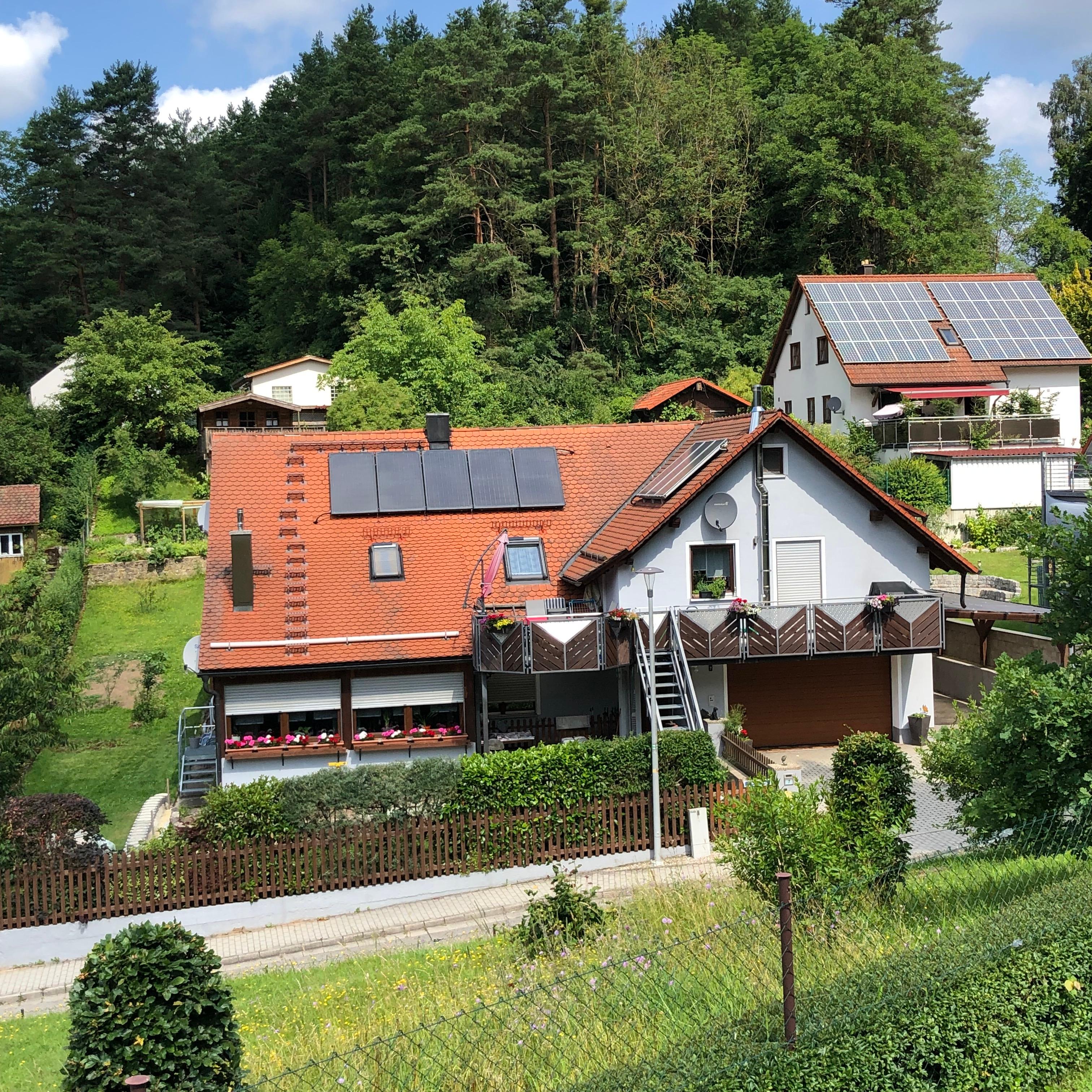 Außenansicht des Hauses mit der Ferienwohnung Waldblick vor bewaldetem Hang